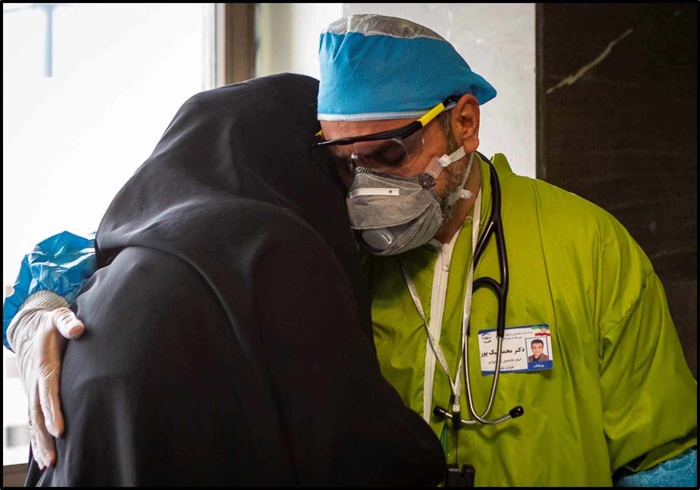 A doctor comforts a woman at a hospital in Tehran